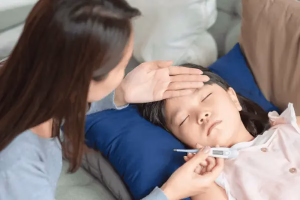 母亲用温度计检查孩子的体温